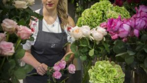 A florist preparing a bouquet of roses